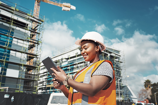Shot of a young woman using a digital tablet while working at a construction site